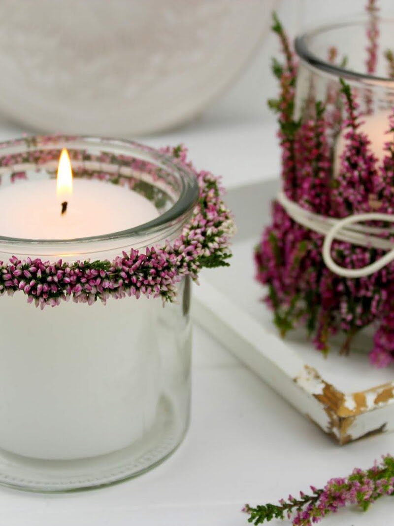 Windlichter und Blumenkränze mit Heidekraut an einem Windlicht