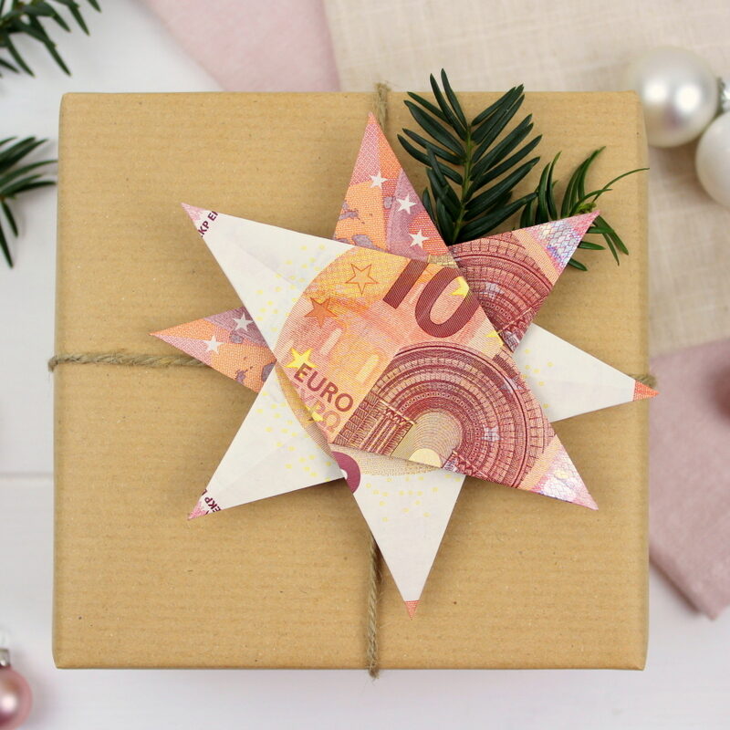 Origami Stern mit 10 Euro Scheinen auf einem Geschenk