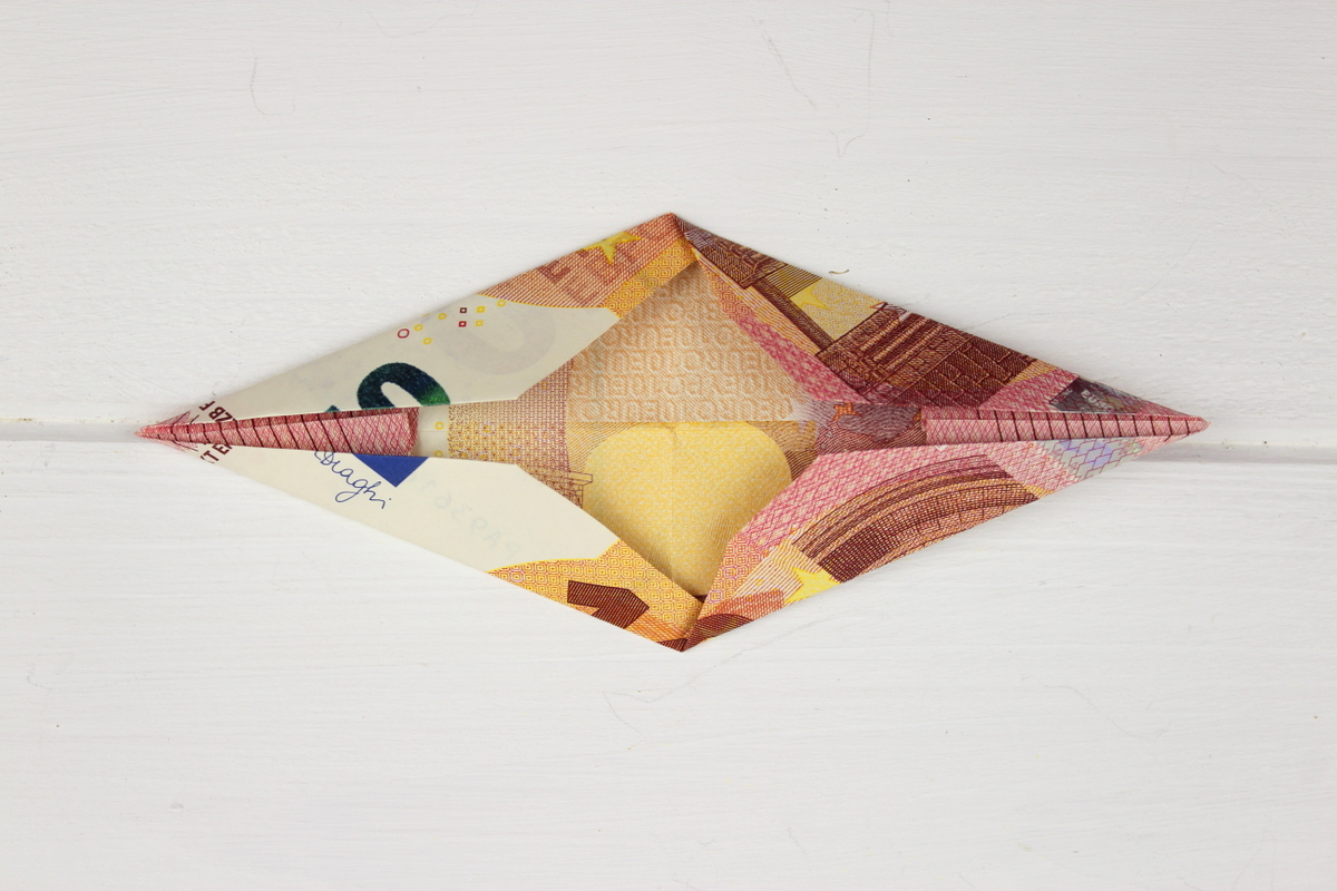 Origami Stern mit 10 Euro Scheinen auf einem Geschenk
