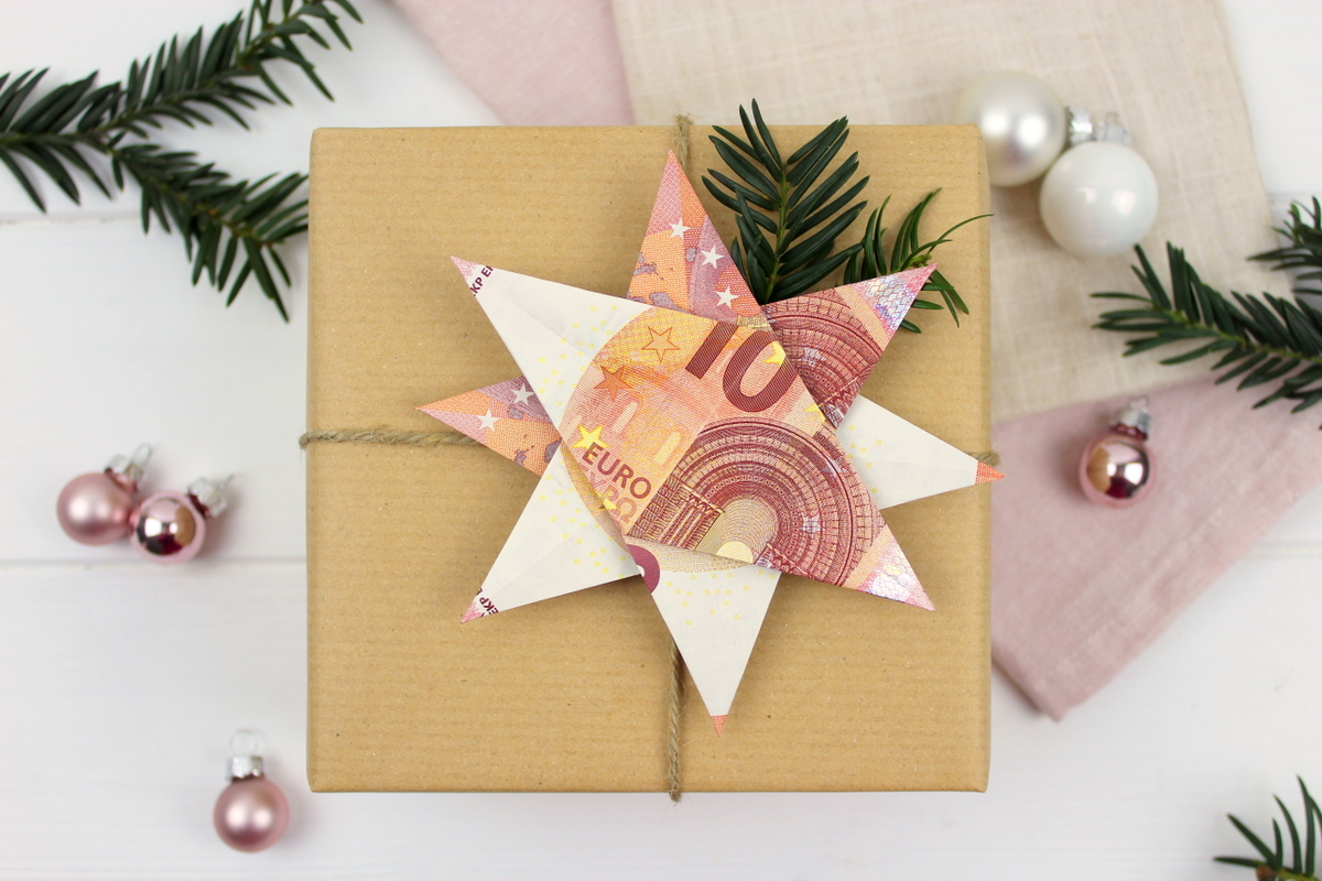 Origami Stern mit 10 Euro Scheinen auf einem Geschenk